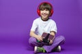 Funny Winsome Girl in White Shirt Posing With Gamepad Joystick And Wireless Headphones While Using Smartphone For Gaming With