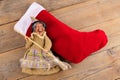 The funny witch Befana and red stocking with sweet coal and candy on wooden background. Italian Epiphany day tradition Royalty Free Stock Photo