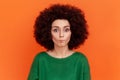 Funny woman with Afro hairstyle in green sweater making fish face with pout lips and looking amazed