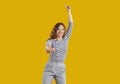 Portrait of happy funny young girl dancing and jumping isolated on yellow background Royalty Free Stock Photo