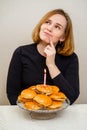 a funny woman makes a wish and blows out a candle on a hamburger cake.