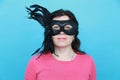 Funny woman wearing party mask accessory. Quirky girl acting playful and having fun celebrating. Humor and joke concept