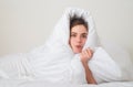 Funny woman wrapped in soft blanket sitting on bed. Smiling girl sitting in bed and smiling at home. Royalty Free Stock Photo