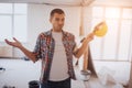 Funny worker with construction helmet Is standing on the cbuilding site and does not know what to do. Royalty Free Stock Photo