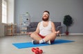 Funny yoga. Fat man doing yoga exercises in the room. Royalty Free Stock Photo