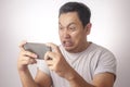 Funny Young Asian Guy Playing Games on Tablet