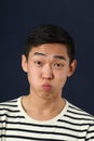 Funny young Asian man making face and looking at camera Royalty Free Stock Photo