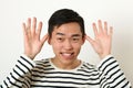 Funny young Asian man making face and looking at camera Royalty Free Stock Photo