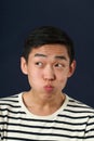 Funny young Asian man making face and looking sideways Royalty Free Stock Photo