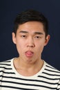 Funny young Asian man making face and showing his tongue Royalty Free Stock Photo