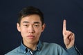 Funny young Asian man pointing his index finger upward Royalty Free Stock Photo