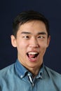Funny young Asian man showing tongue and making face Royalty Free Stock Photo