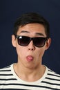 Funny young Asian man in sunglasses showing his tongue Royalty Free Stock Photo