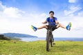 Funny young backpacker riding a bicycle on a meadow