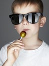 Funny Young Boy Eating A Lollipop.Fashionable child in sunglasses Royalty Free Stock Photo