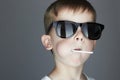 Funny Young Boy Eating A Lollipop.Fashionable child in sunglasses Royalty Free Stock Photo