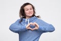 Funny young caucasian man showing heart sign. Healthy diet or love emotion