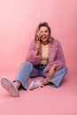 Funny young caucasian woman holding sweet candy, looking at camera on pink background. Royalty Free Stock Photo