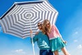 Funny and young couple have fun with beach umbrella on the roof Royalty Free Stock Photo