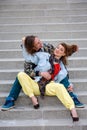 Funny young couple sitting on steps and playing with chewing gum Royalty Free Stock Photo