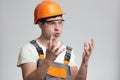 Funny young disgruntled foreman in hysterics on gray isolated background, comic emotions on his face