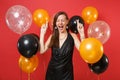 Funny young girl in black dress celebrate waiting for special moment keeping fingers crossed, eyes closed on bright red Royalty Free Stock Photo