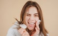 Funny young girl with daily morning skincare procedures, cleansing face skin with natural lotion tonic using cotton disc Royalty Free Stock Photo