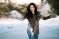 Funny young girl in sweater throws up a snow.