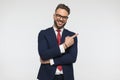 Funny young guy with red tie and elegant suit laughing and pointing fingers to side Royalty Free Stock Photo