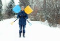 Funny young man holds two snow shovels, forming a symbol of Jolly Roger. Winter seasonal concept