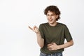 Funny young man laughing, pointing at smth hilarious, chuckle and smile, standing over white background Royalty Free Stock Photo