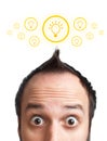 Funny young man with light bulb over his head Royalty Free Stock Photo