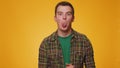 Funny young man showing tongue making faces at camera, fooling around, joking, aping with silly face