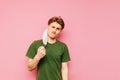 Funny young man takes off his meditation mask and looks at the camera with a skeptical face, isolated on a pink background. Royalty Free Stock Photo