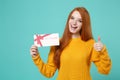 Funny young redhead woman girl in yellow knitted sweater posing isolated on blue turquoise background in studio. People Royalty Free Stock Photo