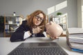 Funny young weird man accountant pointing at piggy bank with finger Royalty Free Stock Photo