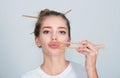 Funny young woman with chopsticks to roll in the mouth. Sexy lips with chopsticks. Royalty Free Stock Photo