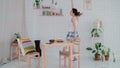 Funny young woman dancing in kitchen wearing pajamas in the morning. Brunette girl in cheerful mood listens music. Royalty Free Stock Photo