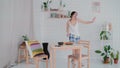 Funny young woman dancing in kitchen wearing pajamas in the morning. Brunette girl in cheerful mood listens music. Royalty Free Stock Photo