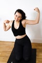 Funny young woman laughing at herself flexing arms after her training Royalty Free Stock Photo