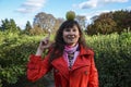 Funny young woman standing in park, smiling and looking into the camera, with green apple on her head. I`am having idea Royalty Free Stock Photo