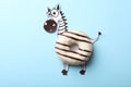 Funny zebra made with donut on light blue background, top view