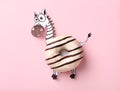 Funny zebra made with donut and piece of paper on background, top view