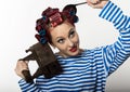 Funy housewife with curlers hold vintage iron and a ladle