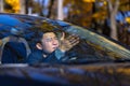 Furious angry asian man standing in a traffic jam beeps and hurries. Sitting in the car. Irritated young business male tired Royalty Free Stock Photo