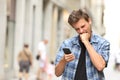 Furious angry man watching mobile phone