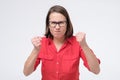 Furious and angry woman in glasses holding fist up