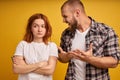 Furious bearded guy screams and gestures angrily, yells at woman, have dispute, pose together over yellow background. Strict boss