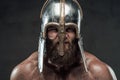 Aggressive viking with helmet on him in dark background