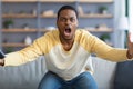 Furious black guy watching football game on TV Royalty Free Stock Photo